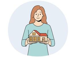 Smiling woman with house model in hands vector