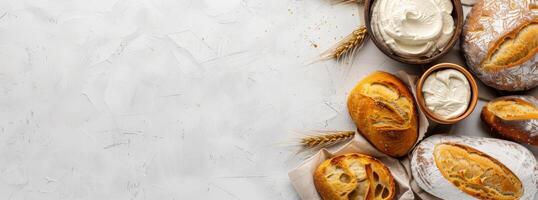 Selection of assorted freshly baked pastries and artisan bread with creamy toppings, on a rustic background. photo