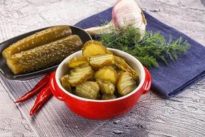 Sliced marinated cucumbers in the bowl photo