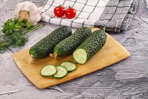 Raw green cucumbers with slices photo