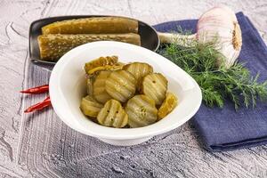 Sliced marinated cucumbers in the bowl photo