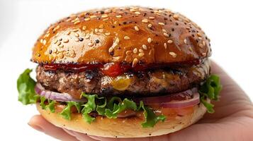 Close up of a Hand Holding a Partially Eaten Burger in Soft Natural Lighting photo