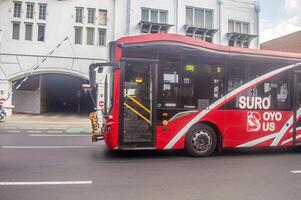 a public transportation bus in the city of Surabaya called Trans Semanggi or Suroboyo Bus that passes on the streets of the city of Surabaya, Indonesia, 20 June 2024. photo