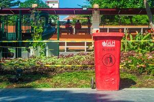 a red trash can in a public park in Surabaya, Indonesia, 20 June 2024. photo