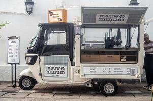 street coffee shop car entrepreneur who sells contemporary drinks such as coffee milk espresso using a modified bajaj into a mobile coffee shop, Indonesia, 20 June 2024. photo