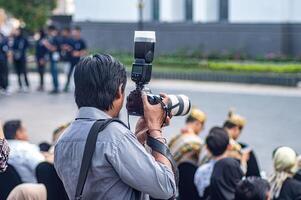 a media photographer or journalist or press who captures moments at a soft launch event in the old city of Surabaya, Indonesia, 20 June 2024. photo