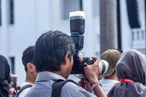 a media photographer or journalist or press who captures moments at a soft launch event in the old city of Surabaya, Indonesia, 20 June 2024. photo
