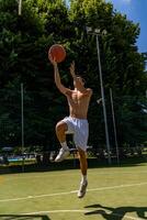 young caucasian basketball player athlete in action jumping on artificial turf playing field on a sunny summer day photo