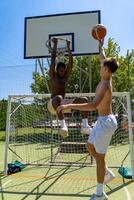 two young multiethnic athletes basketball players in action jumping on artificial grass playing field on a sunny summer day photo
