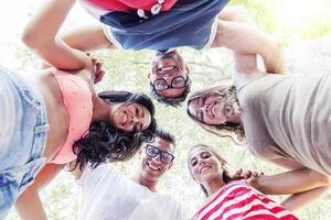 group of smiling friends in circle - bottom view photo