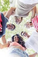 group of smiling friends in circle - bottom view photo