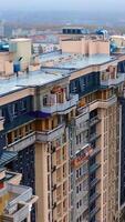 Construction site in the city. Modern architecture is building by workers. High-rise building under construction. Camera moves in a round way. Aerial view. Vertical video