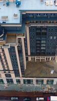 Building of multi-storey architecture. Modern tall apartment building under construction in the city. Aerial view. Vertical video