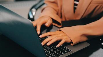 Cropped image of professional businesswoman working at her office via laptop, young female manager using portable computer device while sitting at modern loft, flare light, work process concept video