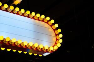 Yellow neon light sign red frame and white copy space for add text against black background. Modern lighted signs for decorating buildings or place. photo