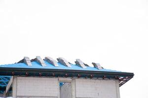 Gray roof of house under house building construction site against blue sky. New tile roof of home with spanish tiled roof at unfinished house construction, Preparation for laying roof tiles structure. photo