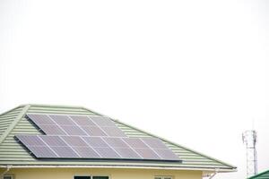 Installing a solar cell on a roof. Solar panels on roof. Modern house with modern solar panels on tile roof and wall against clear sky background 2025. photo