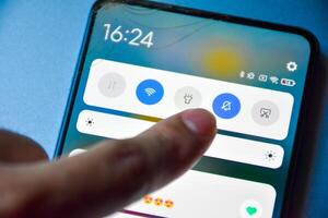 Finger pressing to turn off notification mode on Android mobile phone display screen and notification of matches in dating applications, Finger presses off the interference button. photo