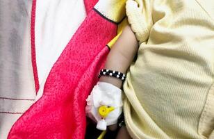 Children patient's hand recieving iv saline solution in hostpital photo