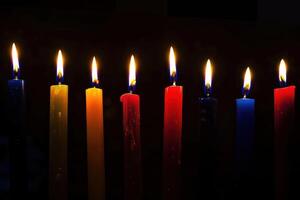 A set of lit Hanukkah candles lined up. In the form of dark, foreboding, contrasting colors. photo