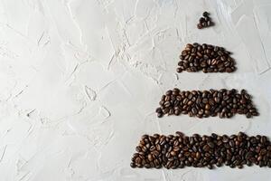 Pyramid of coffee beans divided into four parts, horizontal division, top view, flat light background. photo