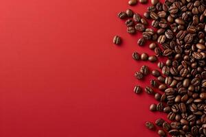 Coffee beans viewed from above scattered on a red background. photo
