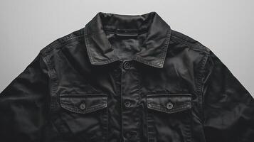 Close-up of a simple black shirt. By emphasizing details on the front contrasting with the white background. photo