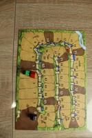 board game carcassonne tablet for calculating the progress of players' points. Meeply on the map as seen from above photo