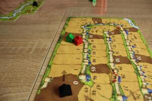 board game carcassonne for a family friendly evening. Meeples on the tablet to calculate the progress of the players' points, points photo