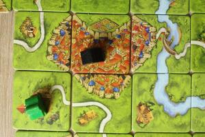 board game carcassonne meeples of different colors green black on the map top view of the rules of occupied objects of the city of the monastery. Score Points photo