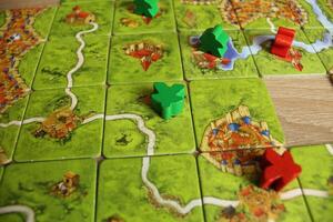 board game carcassonne red green meeple lie on the field map game rules for occupying the field photo