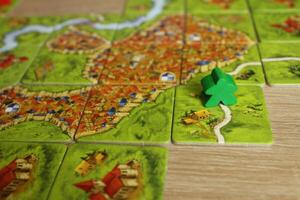 Carcassonne green meeple family board game took the road on a tile with a road. Rules for connecting hoists to the road photo