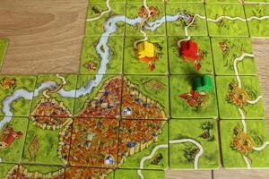 The playing field of the board game carcassonne. Colorful meeples on the playing field photo