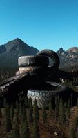 concept of environmental pollution with big old tires in mountain forest video