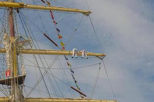 Masts and rigging of a sailing ship against blue sky and clouds. High quality photo