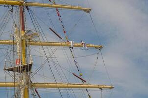 Masts and rigging of a sailing ship against blue sky and clouds.with sailor . High quality photo