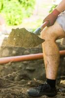 Guy is digging ground. Man with shovel. Digging up soil. Work on land. High quality photo