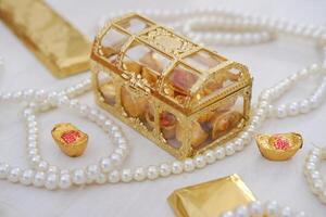 golden box with chocolate and gold chocolate bars on a wooden background. chinese new year photo