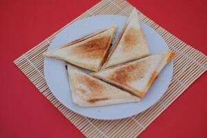 Toasted bread on a white plate isolated on a red background. photo