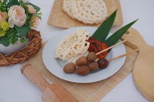 rice with skewered quail eggs and crackers on wood background. Selective focus. photo