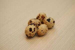 Quail eggs on a wooden background. Close-up, selective focus. photo