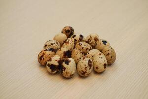 Quail eggs on a wooden background. Close-up, selective focus. photo