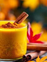 warm autumn spice drink with cinnamon sticks and ground cinnamon in glass. photo