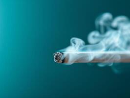 abstract smoke from burning incense stick on teal background - close up photography. photo