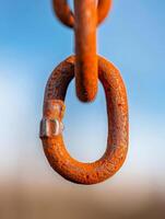 close-up of a rusty chain link against a blue sky - macro photography. photo