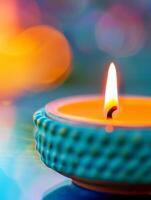 close-up of burning candle with bokeh background - teal and orange hues. photo