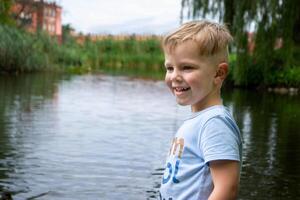 Small boy playing on a pond. photo