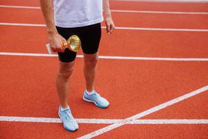 A track runner is standing at the starting line, getting ready for a quick sprint photo