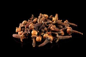 Clove spice pile on black isolate photo
