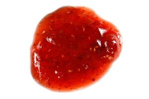 Drop of raspberry jam on white isolate. Raspberry jam spots photo